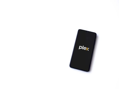 Lod, Israel - July 16,2023: Plex app launch screen on smartphone on white background. Top view flat lay with copy space.