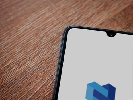 Lod, Israel - July 16,2023: Nexo app launch screen on smartphone on wooden background. Top view flat lay with copy space.