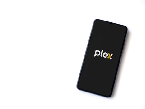 Lod, Israel - July 16,2023: Plex app launch screen on smartphone on white background. Top view flat lay with copy space.