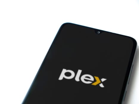 Lod, Israel - July 16,2023: Plex app launch screen on smartphone on white background. Top view flat lay with copy space.