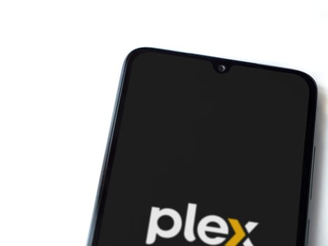 Lod, Israel - July 16,2023: Plex app launch screen on smartphone on white background. Top view flat lay with copy space.