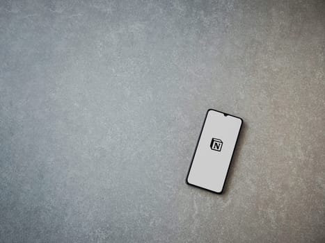 Lod, Israel - July 16,2023: Notion app launch screen on smartphone on ceramic stone background. Top view flat lay with copy space.