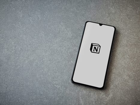 Lod, Israel - July 16,2023: Notion app launch screen on smartphone on ceramic stone background. Top view flat lay with copy space.