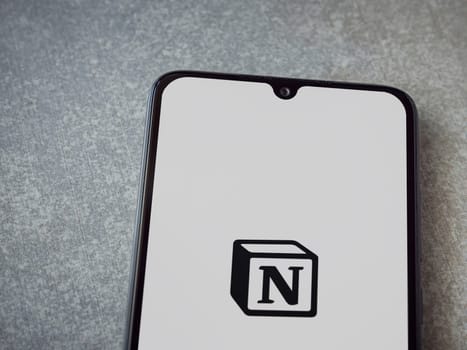 Lod, Israel - July 16,2023: Notion app launch screen on smartphone on ceramic stone background. Top view flat lay with copy space.