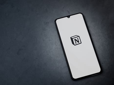 Lod, Israel - July 16,2023: Notion app launch screen on smartphone on dark marble stone background. Top view flat lay with copy space.
