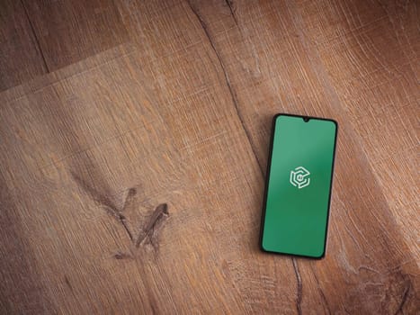 Lod, Israel - July 16,2023: Adam Ai app launch screen on smartphone on wooden background. Top view flat lay with copy space.