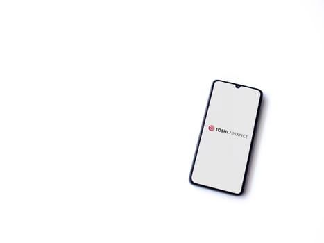 Lod, Israel - July 16,2023: Toshl Finance app launch screen on smartphone on white background. Top view flat lay with copy space.