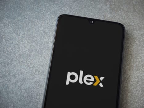 Lod, Israel - July 16,2023: Plex app launch screen on smartphone on ceramic stone background. Top view flat lay with copy space.