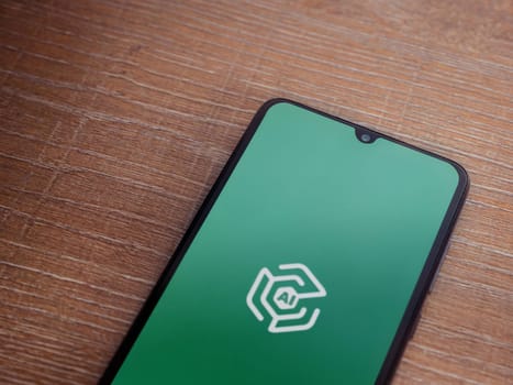 Lod, Israel - July 16,2023: Adam Ai app launch screen on smartphone on wooden background. Top view flat lay with copy space.