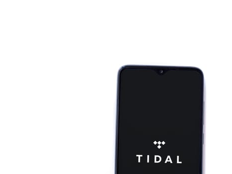 Lod, Israel - July 16,2023: TIDAL Music app launch screen on smartphone on white background. Top view flat lay with copy space.