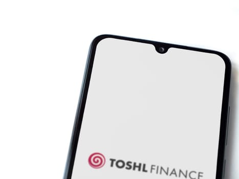 Lod, Israel - July 16,2023: Toshl Finance app launch screen on smartphone on white background. Top view flat lay with copy space.