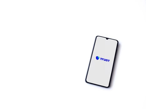 Lod, Israel - July 16,2023: Trust Wallet app launch screen on smartphone on white background. Top view flat lay with copy space.