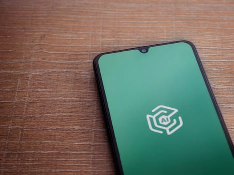 Lod, Israel - July 16,2023: Adam Ai app launch screen on smartphone on wooden background. Top view flat lay with copy space.