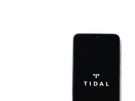 Lod, Israel - July 16,2023: TIDAL Music app launch screen on smartphone on white background. Top view flat lay with copy space.