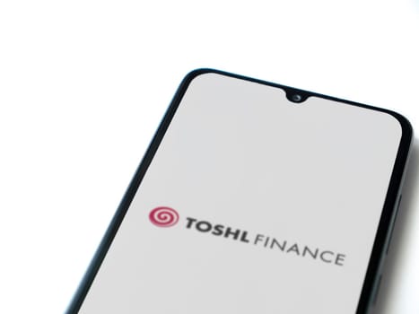 Lod, Israel - July 16,2023: Toshl Finance app launch screen on smartphone on white background. Top view flat lay with copy space.