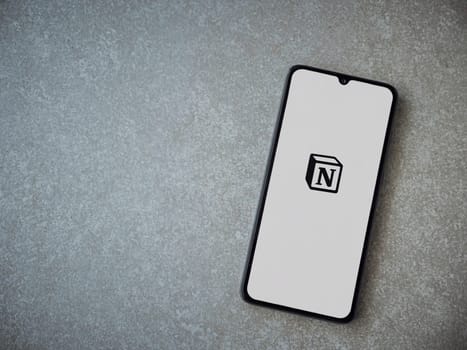 Lod, Israel - July 16,2023: Notion app launch screen on smartphone on ceramic stone background. Top view flat lay with copy space.