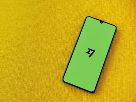 Lod, Israel - July 16,2023: Wise app launch screen on smartphone on yellow fabric background. Top view flat lay with copy space.