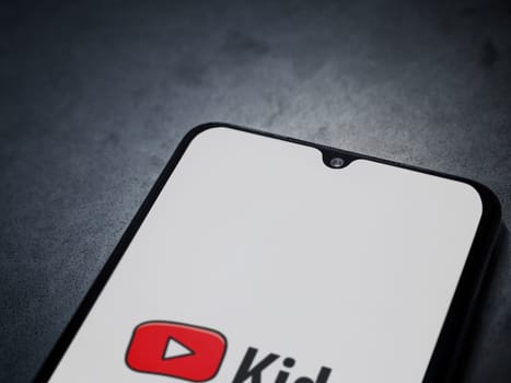 Lod, Israel - July 16,2023: YouTube Kids app launch screen on smartphone on dark marble stone background. Top view flat lay with copy space.