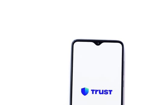 Lod, Israel - July 16,2023: Trust Wallet app launch screen on smartphone on white background. Top view flat lay with copy space.