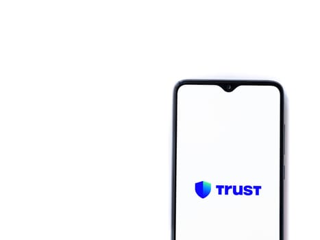 Lod, Israel - July 16,2023: Trust Wallet app launch screen on smartphone on white background. Top view flat lay with copy space.