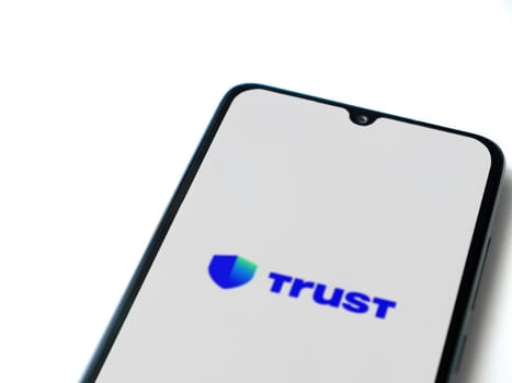 Lod, Israel - July 16,2023: Trust Wallet app launch screen on smartphone on white background. Top view flat lay with copy space.