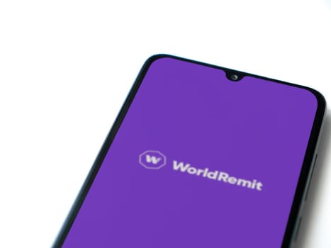 Lod, Israel - July 16,2023: WorldRemit app launch screen on smartphone on white background. Top view flat lay with copy space.