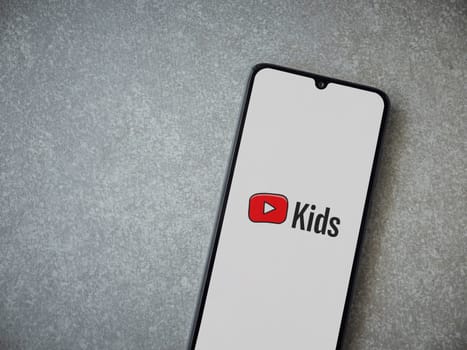 Lod, Israel - July 16,2023: YouTube Kids app launch screen on smartphone on ceramic stone background. Top view flat lay with copy space.