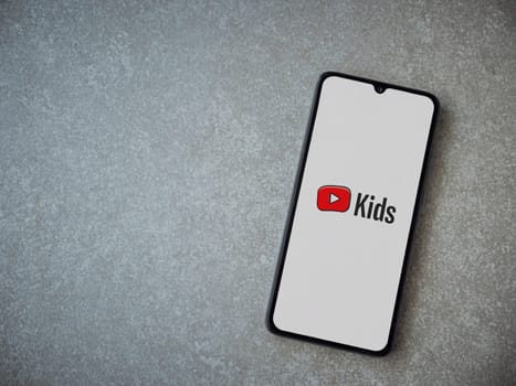 Lod, Israel - July 16,2023: YouTube Kids app launch screen on smartphone on ceramic stone background. Top view flat lay with copy space.