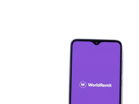 Lod, Israel - July 16,2023: WorldRemit app launch screen on smartphone on white background. Top view flat lay with copy space.