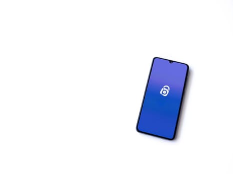 Lod, Israel - July 16,2023: IDrive Photo Backup app launch screen on smartphone on white background. Top view flat lay with copy space.