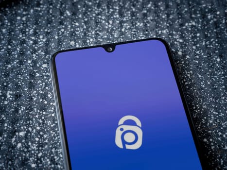Lod, Israel - July 16,2023: IDrive Photo Backup app launch screen on smartphone on metallic background. Close up top view flat lay.