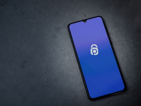 Lod, Israel - July 16,2023: IDrive Photo Backup app launch screen on smartphone on dark marble stone background. Top view flat lay with copy space.