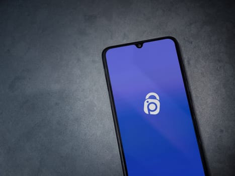 Lod, Israel - July 16,2023: IDrive Photo Backup app launch screen on smartphone on dark marble stone background. Top view flat lay with copy space.