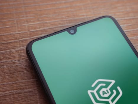Lod, Israel - July 16,2023: Adam Ai app launch screen on smartphone on wooden background. Top view flat lay with copy space.