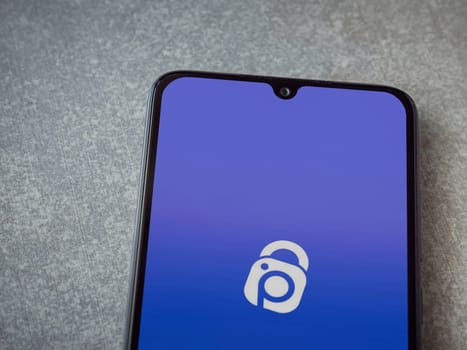 Lod, Israel - July 16,2023: IDrive Photo Backup app launch screen on smartphone on ceramic stone background. Top view flat lay with copy space.