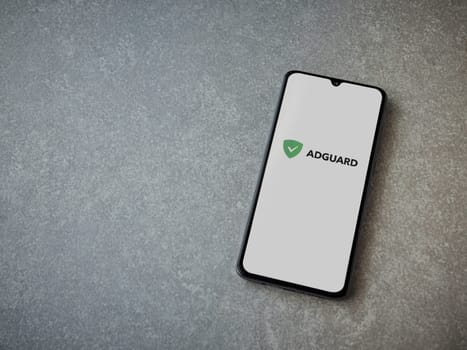 Lod, Israel - July 16,2023: AdGuard app launch screen on smartphone on ceramic stone background. Top view flat lay with copy space.