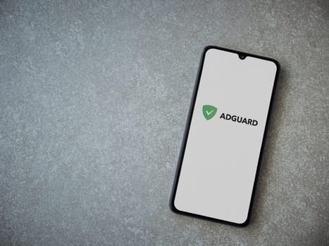 Lod, Israel - July 16,2023: AdGuard app launch screen on smartphone on ceramic stone background. Top view flat lay with copy space.