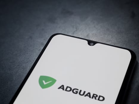 Lod, Israel - July 16,2023: AdGuard app launch screen on smartphone on dark marble stone background. Top view flat lay with copy space.