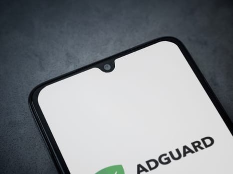 Lod, Israel - July 16,2023: AdGuard app launch screen on smartphone on dark marble stone background. Top view flat lay with copy space.