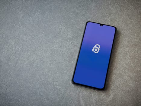 Lod, Israel - July 16,2023: IDrive Photo Backup app launch screen on smartphone on ceramic stone background. Top view flat lay with copy space.