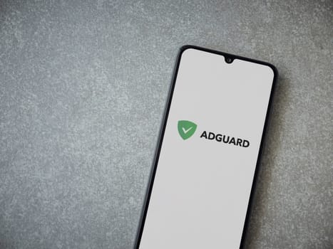 Lod, Israel - July 16,2023: AdGuard app launch screen on smartphone on ceramic stone background. Top view flat lay with copy space.