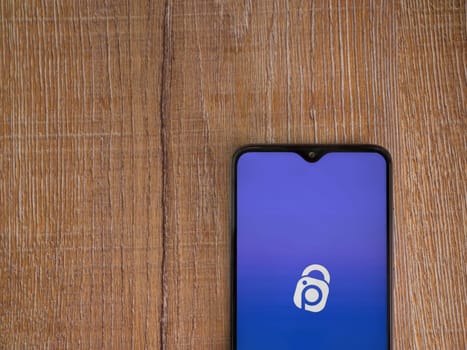 Lod, Israel - July 16,2023: IDrive Photo Backup app launch screen on smartphone on wooden background. Top view flat lay with copy space.