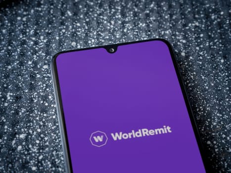 Lod, Israel - July 16,2023: WorldRemit app launch screen on smartphone on metallic background. Close up top view flat lay.