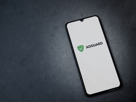 Lod, Israel - July 16,2023: AdGuard app launch screen on smartphone on dark marble stone background. Top view flat lay with copy space.