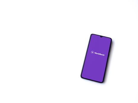 Lod, Israel - July 16,2023: WorldRemit app launch screen on smartphone on white background. Top view flat lay with copy space.