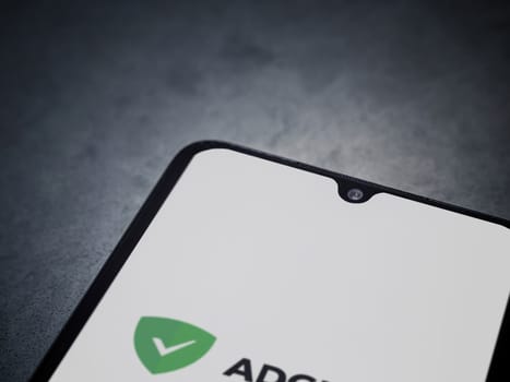Lod, Israel - July 16,2023: AdGuard app launch screen on smartphone on dark marble stone background. Top view flat lay with copy space.