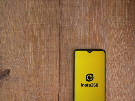 Lod, Israel - July 16,2023: Insta360 app launch screen on smartphone on wooden background.. Top view flat lay with copy space.
