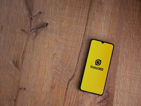 Lod, Israel - July 16,2023: Insta360 app launch screen on smartphone on wooden background.. Top view flat lay with copy space.