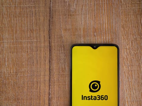 Lod, Israel - July 16,2023: Insta360 app launch screen on smartphone on wooden background.. Top view flat lay with copy space.