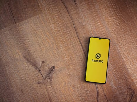 Lod, Israel - July 16,2023: Insta360 app launch screen on smartphone on wooden background. Top view flat lay with copy space.